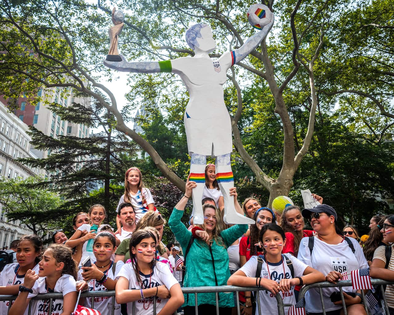 Football fans with a statue of Megan Rapinoe.