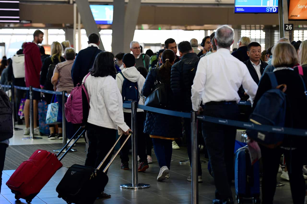 People are seen lining up at Sydney Airport, Sydney.