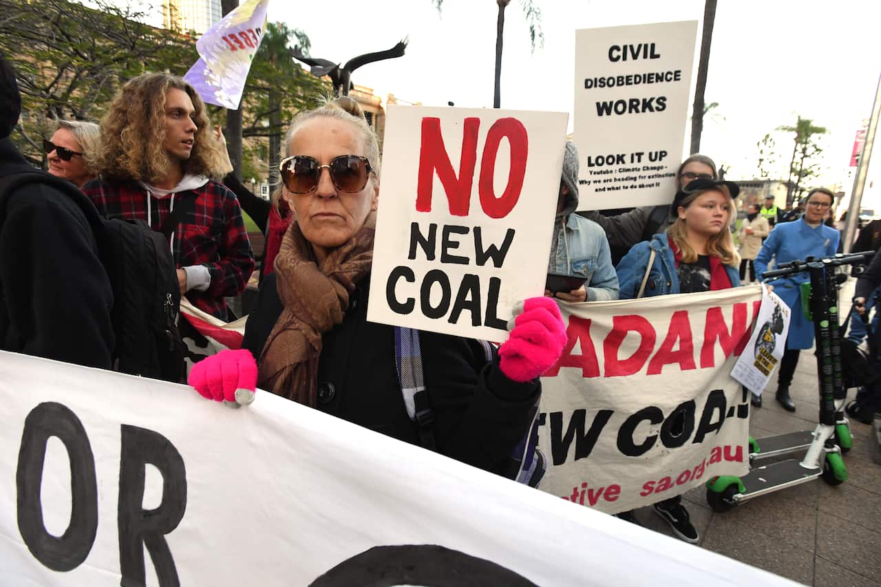 Members of an environmental protest group Extinction Rebellion are seen marching during morning peak-hour in the central business district of Brisbane, Wednesday, July 17, 2019. (AAP Image/Dave Hunt) NO ARCHIVING