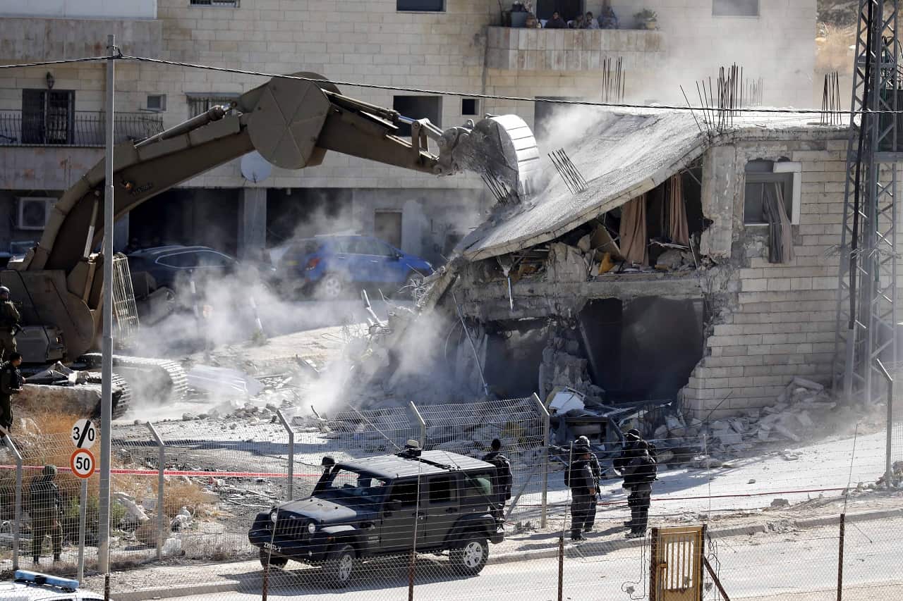 An Israeli army bulldozer demolishes a building on Monday.