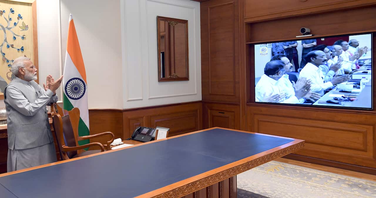 Indian Prime minister Narendra Modi claps as he watches the live telecast of the big moment.