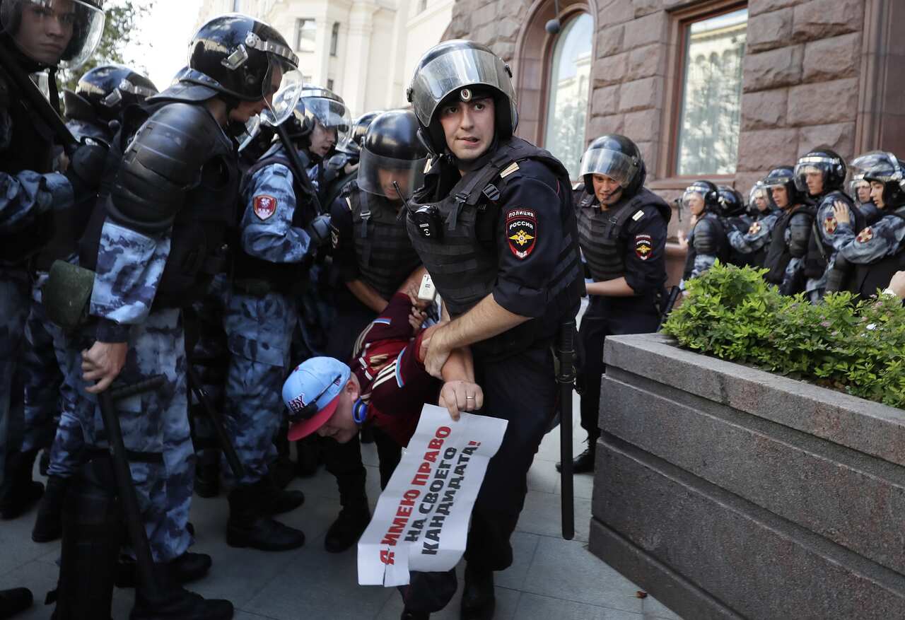 Russian riot police detain a participant during a liberal opposition protest in front of Moscow.
