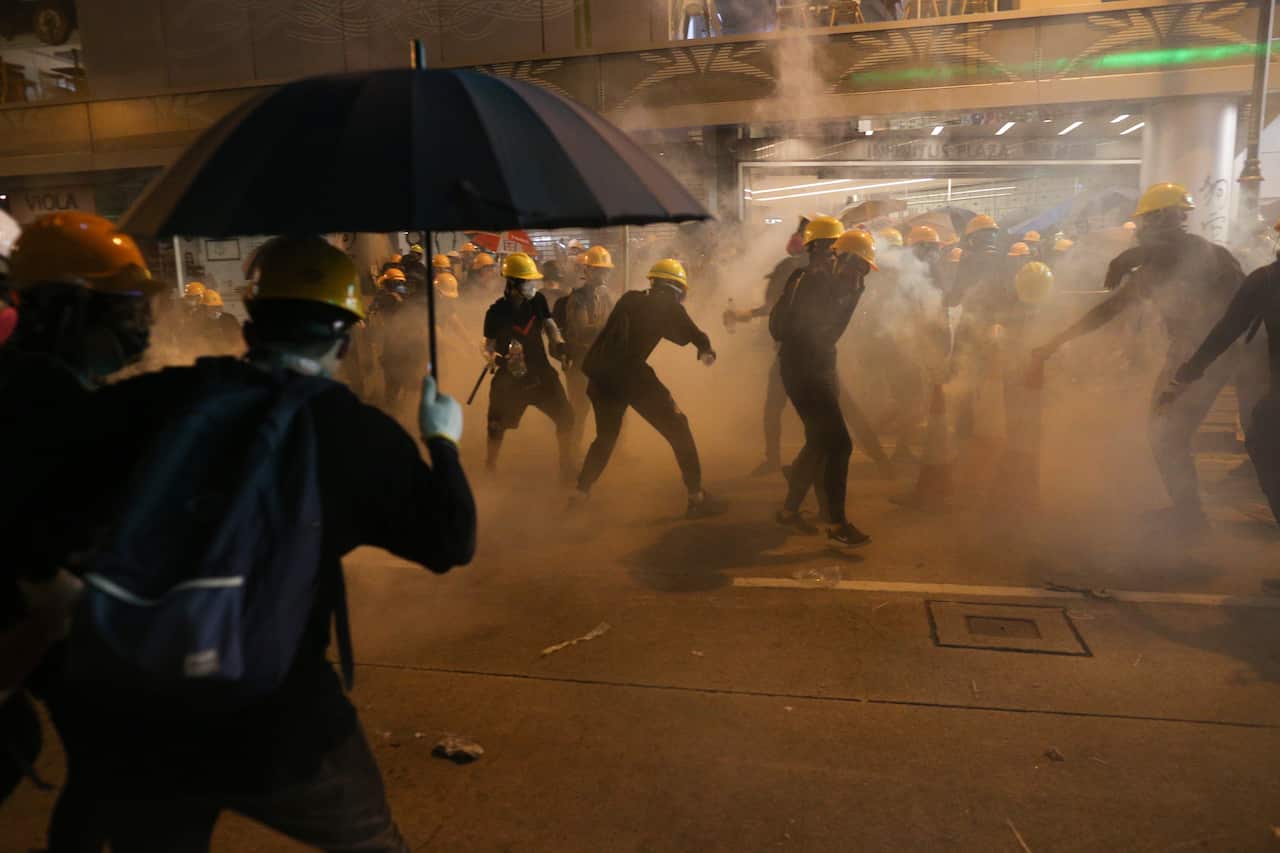 Anti-extradition bill protesters stand surrounded by tear gas smoke fired by riot police during a rally against the police brutality in Hong Kong, China.
