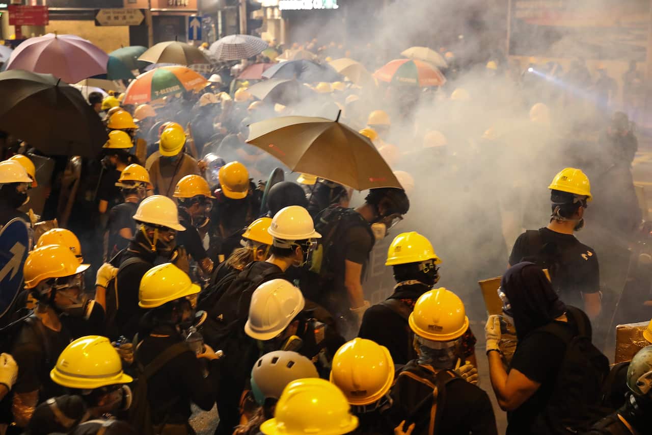 Anti-extradition bill protesters stand surrounded by tear gas smoke fired by riot police during a rally against the police brutality in Hong Kong, China.