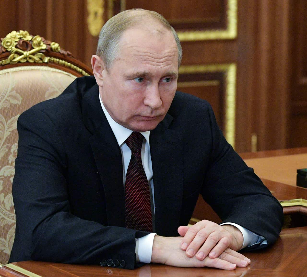 Russian President Vladimir Putin listens to head of the Russian Federal Antimonopoly Service Igor Artemyev during their meeting at the Kremlin in Moscow, Russia