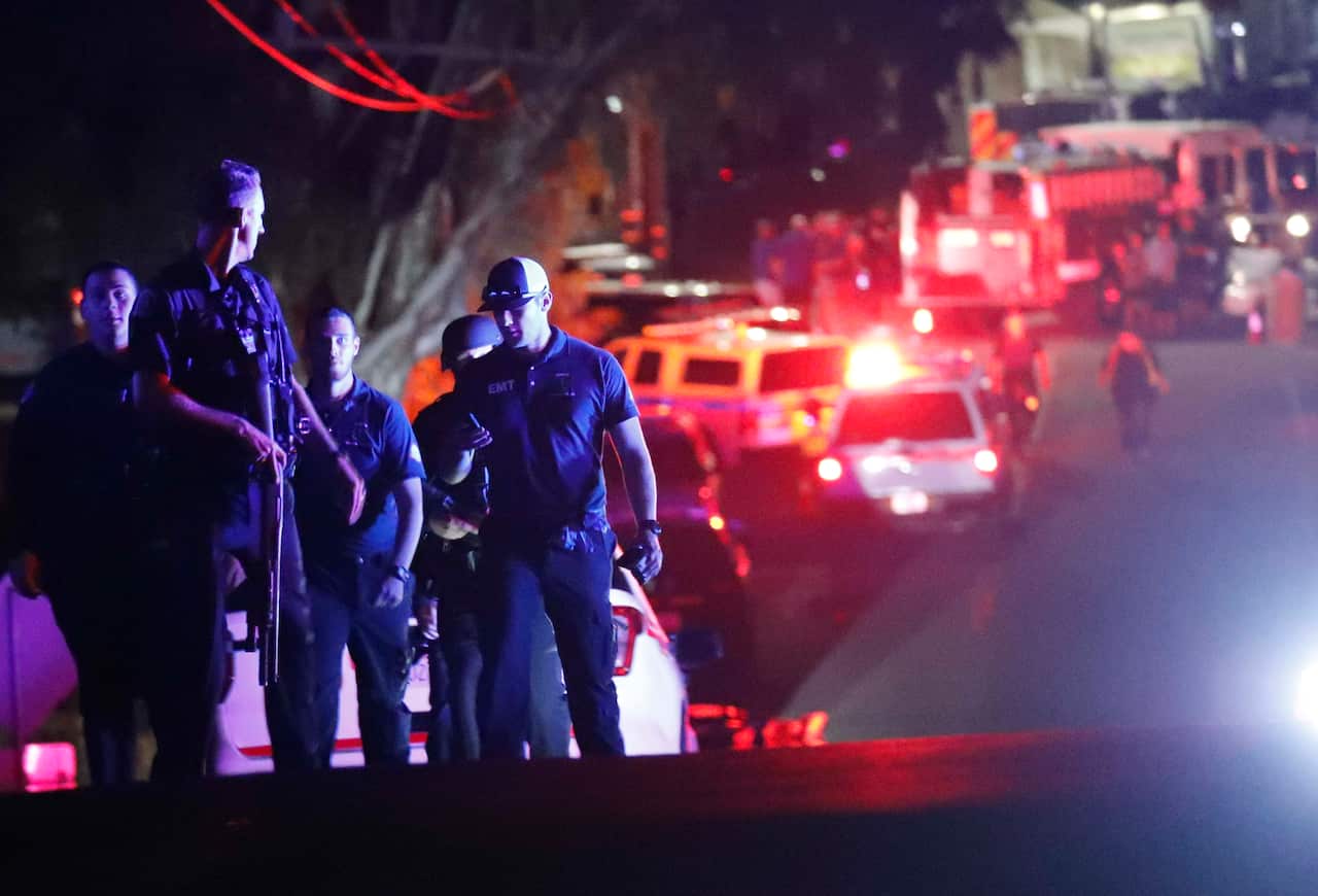 Law enforcement officers near the entrance of Christmas Hill Park where an active gunman fired upon patrons killing three and injuring around 15 people.
