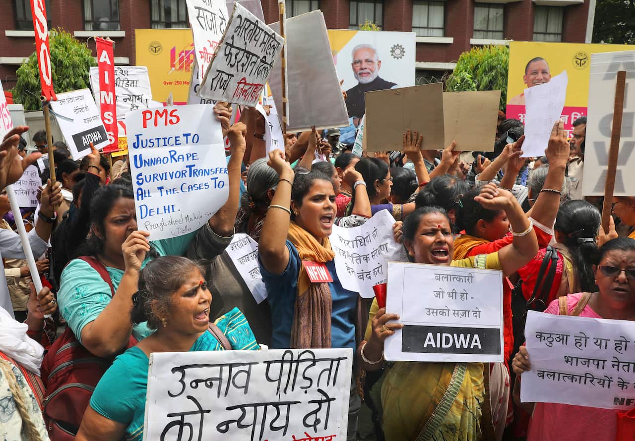Women activists shout slogans during a protest demanding a fast-track probe into a highway accident that critically injured the woman.