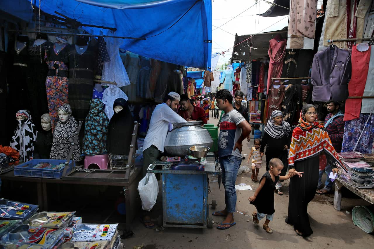 Indian Muslim women walk in a market place in New Delhi, India.