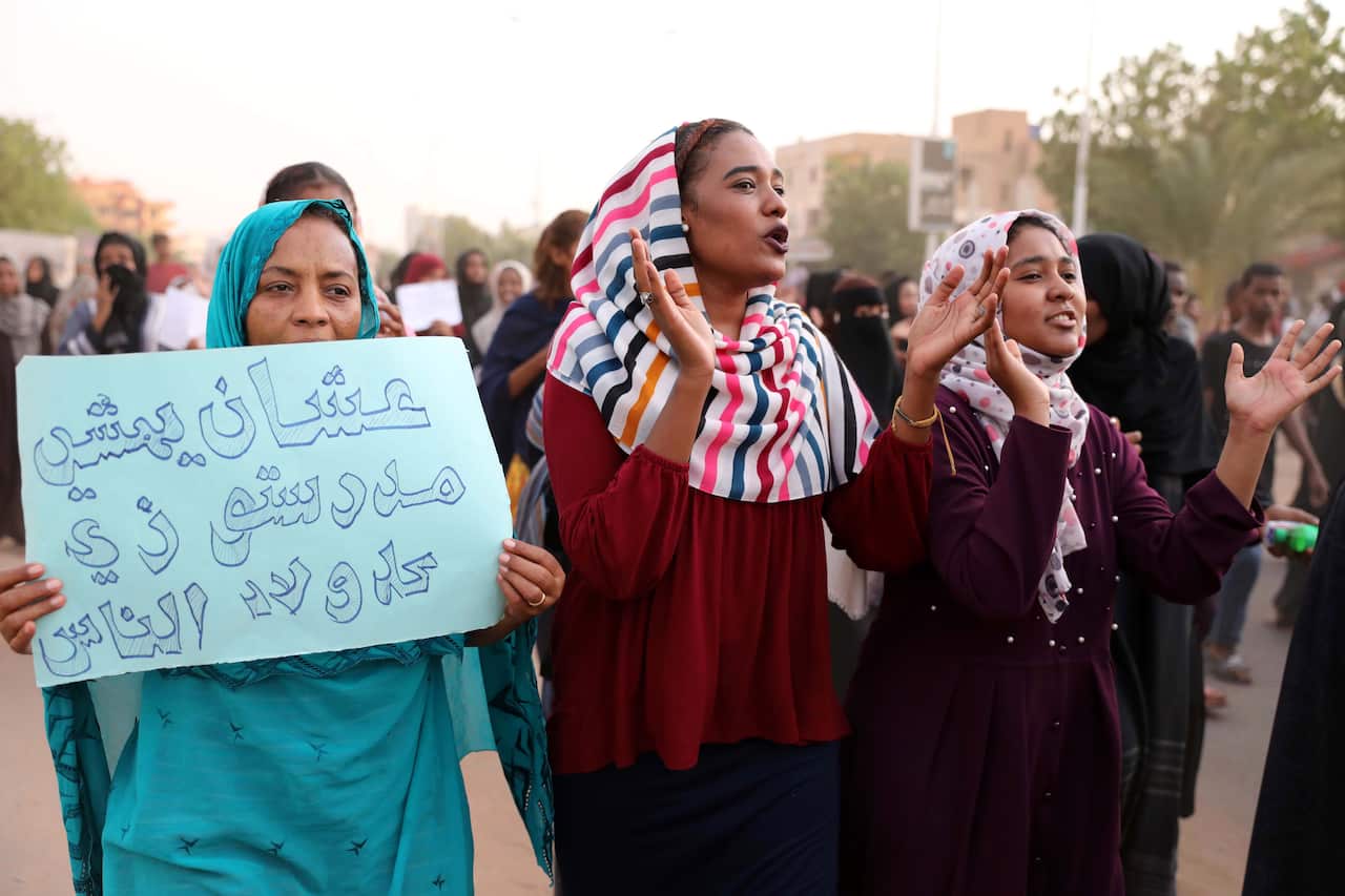 The placard reads 'Because he was walking to school like every one else'.