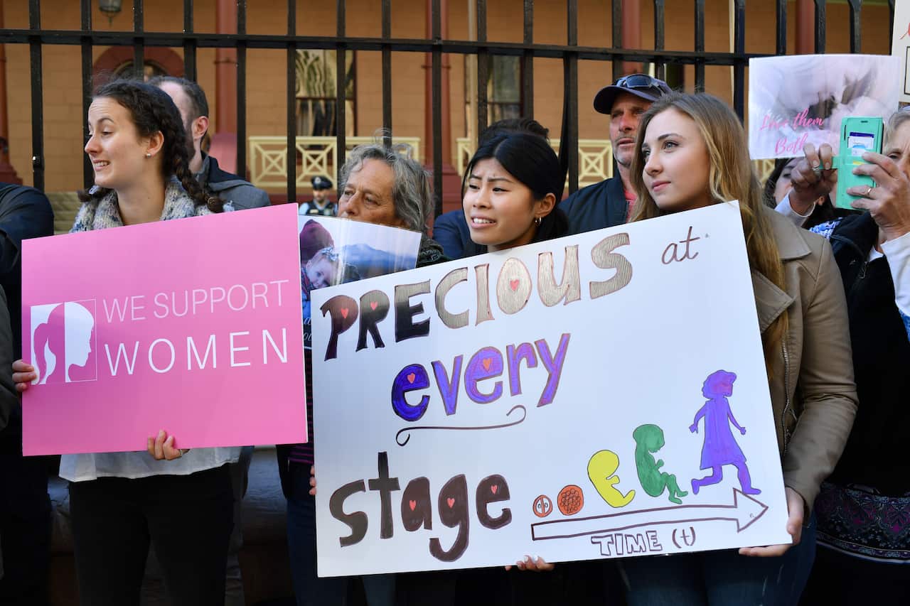 Anti-abortion protesters hold signs during a rally outside the New South Wales Parliament.