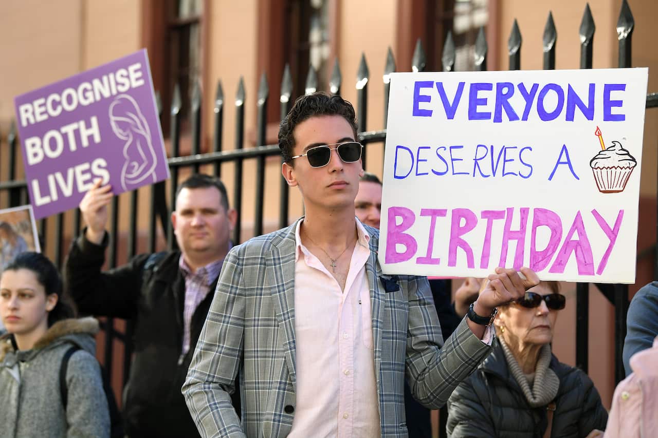 Anti-abortion protesters hold signs during a rally outside the New South Wales Parliament.