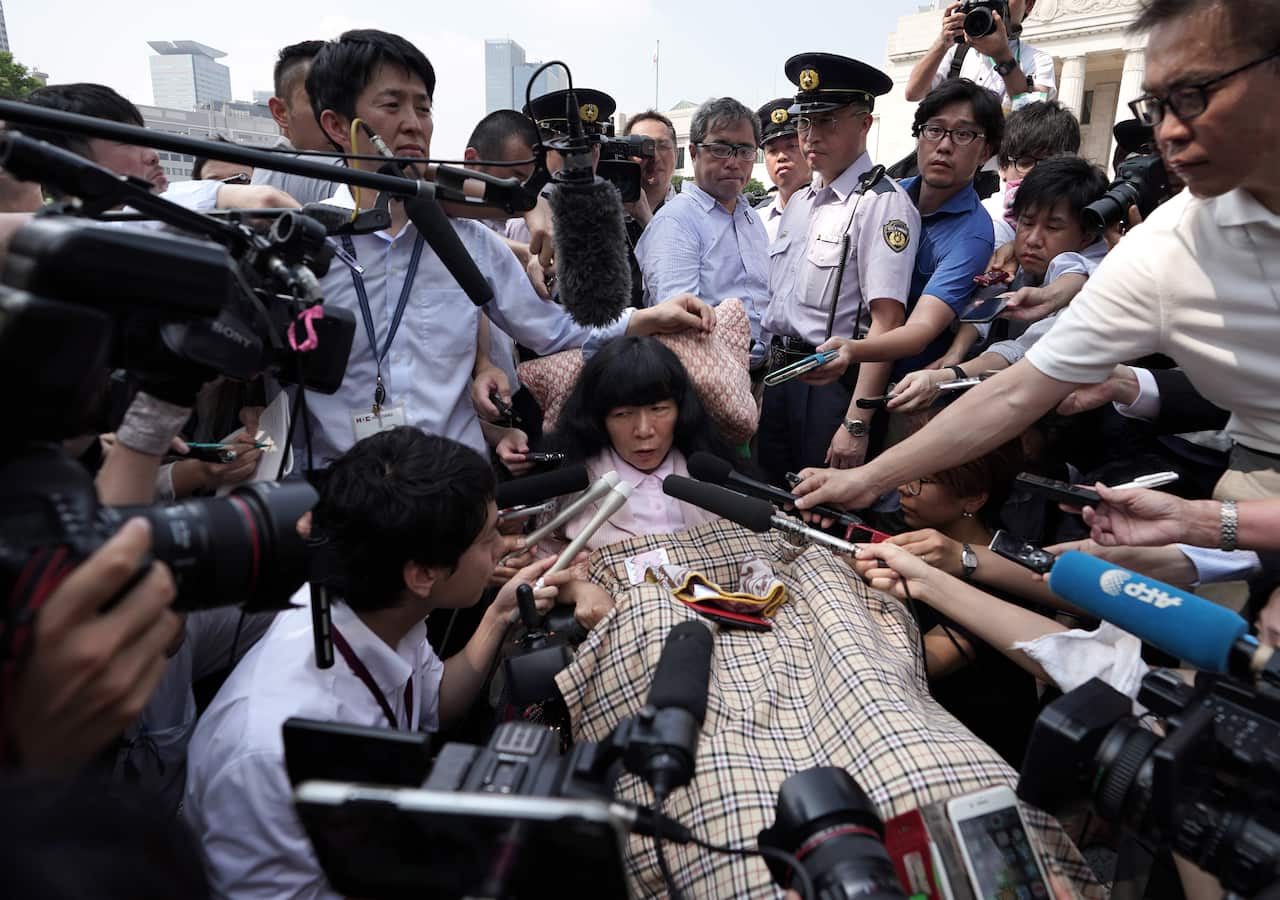 Eiko Kimura sits in her wheelchair in front of the front entrance of the parliament building to attend an extraordinary parliamentary session in Tokyo, Japan