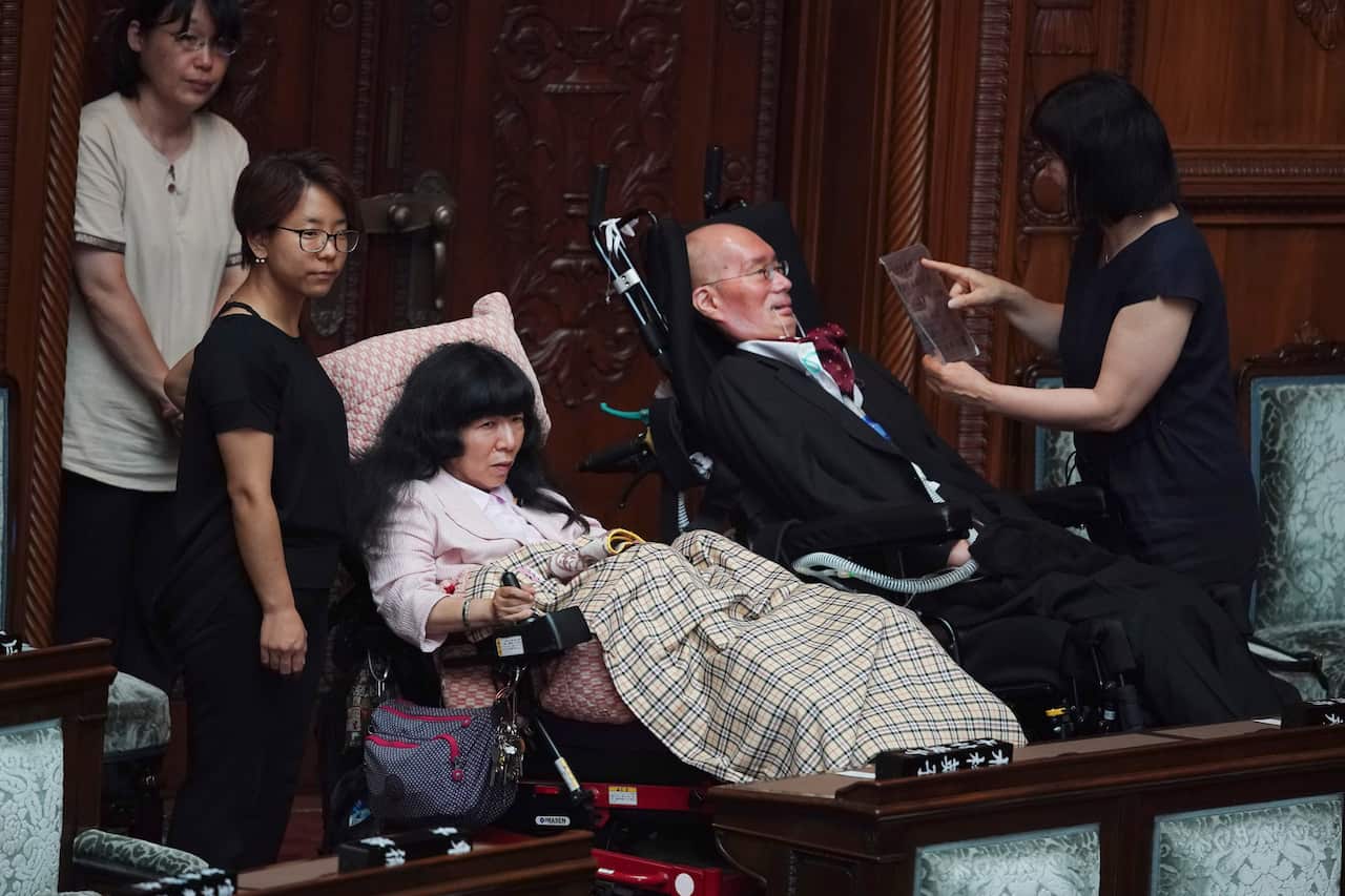 Newly-elected lawmakers in wheelchairs, Eiko Kimura, center left, and Yasuhiko Funago.