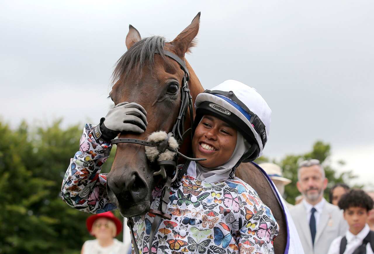 British Jockey Khadijah Mellah cuddles her horse Haverland after winning the all-female Magnolia Cup.