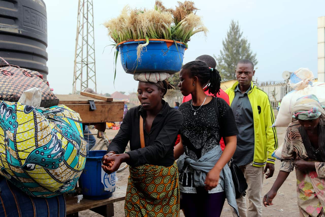 People wash their hands at the border between Congo and Rwanda. 