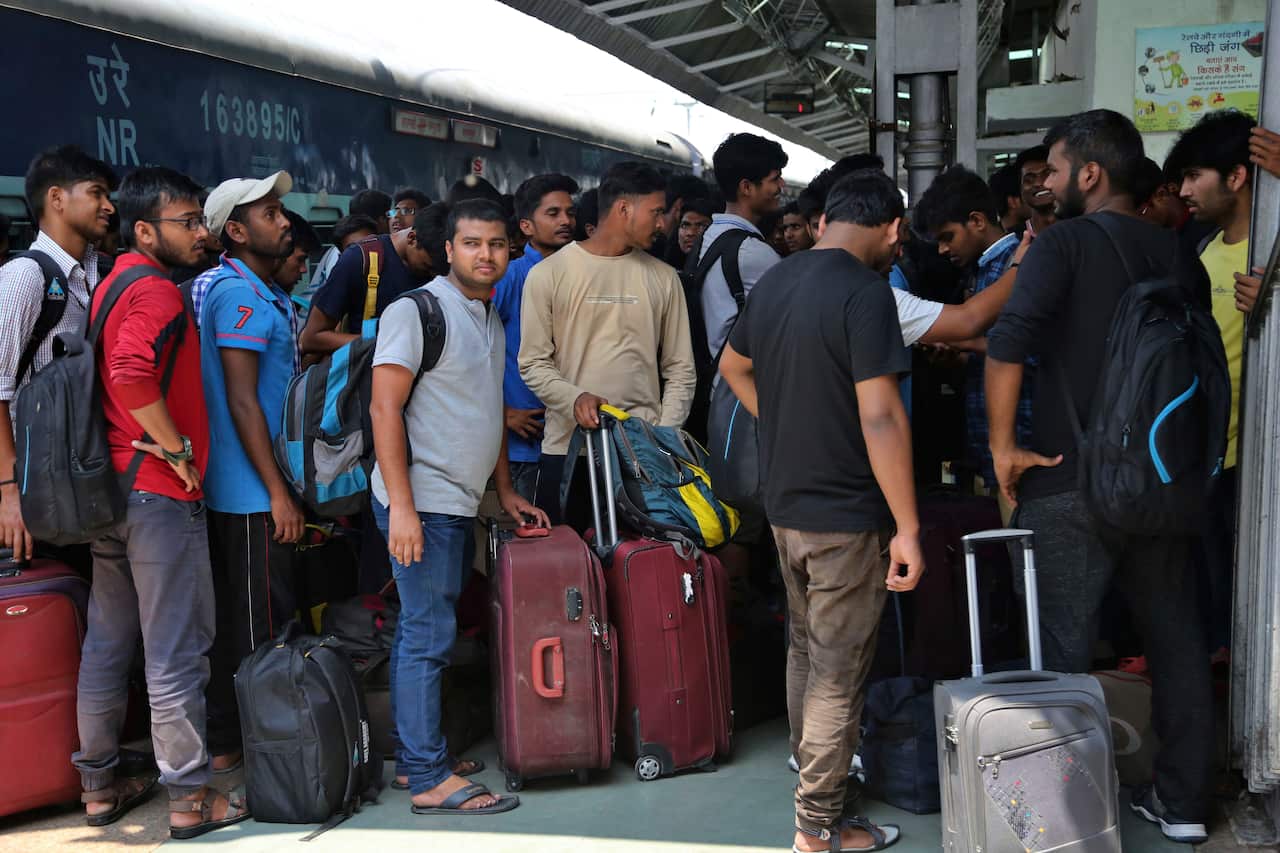 National Institute of Technology Srinagar (NIT) students carrying their luggage to leave railways station in Jammu, India, Sunday, Aug.4,2019. 