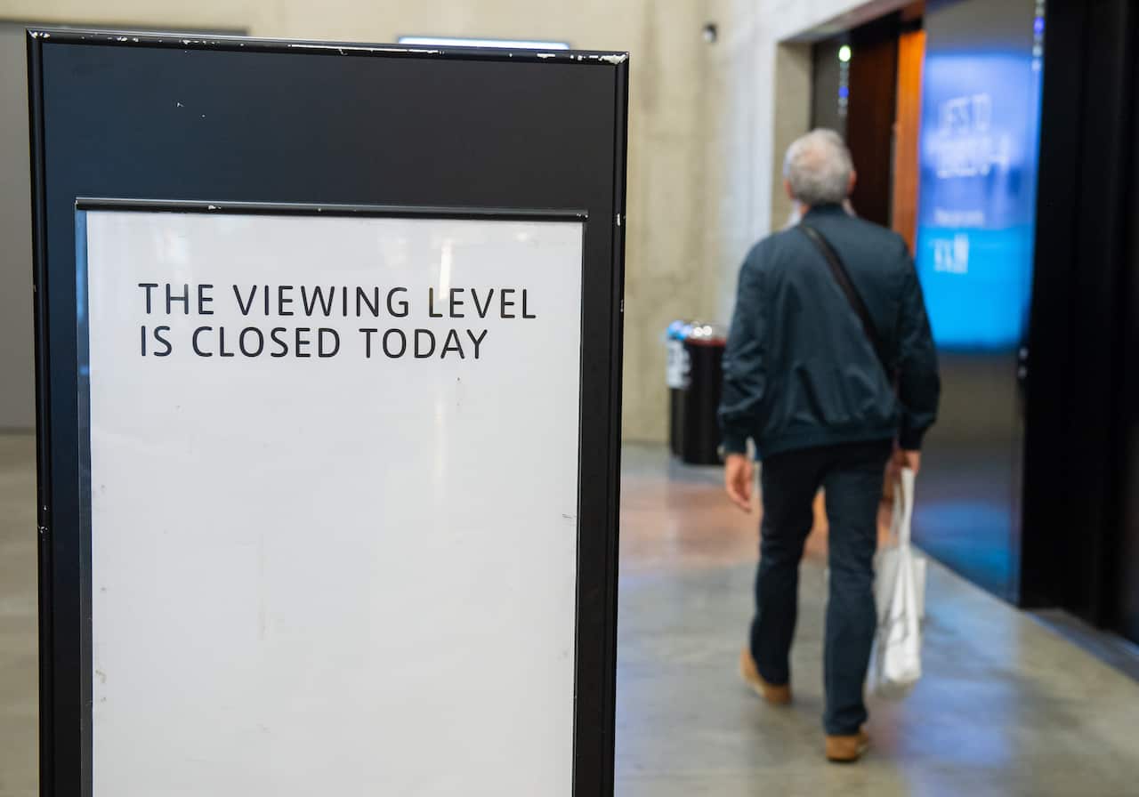 A member of the public walks past a closed sign at the Tate Modern art gallery in London.