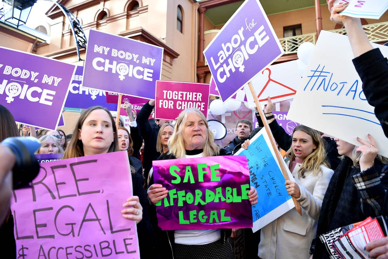 Abortion rights advocates hold placards during a rally outside the New South Wales Parliament House.