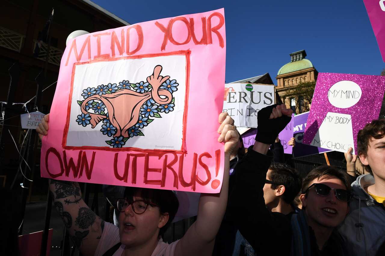 Pro-choice advocates hold placards during a rally outside the New South Wales Parliament house in Sydney.