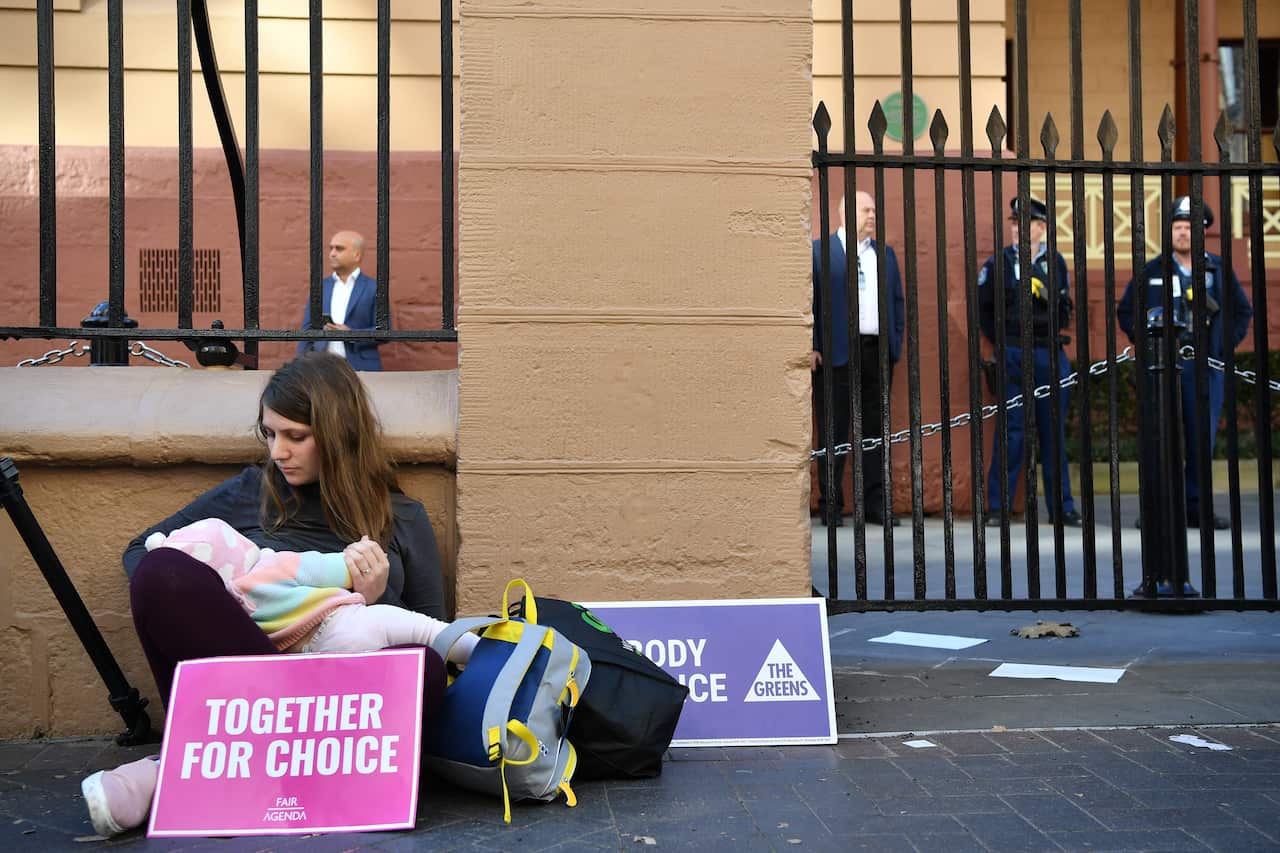 A Pro-choice advocate seen with her baby during a rally outside the New South Wales Parliament house in Sydney.