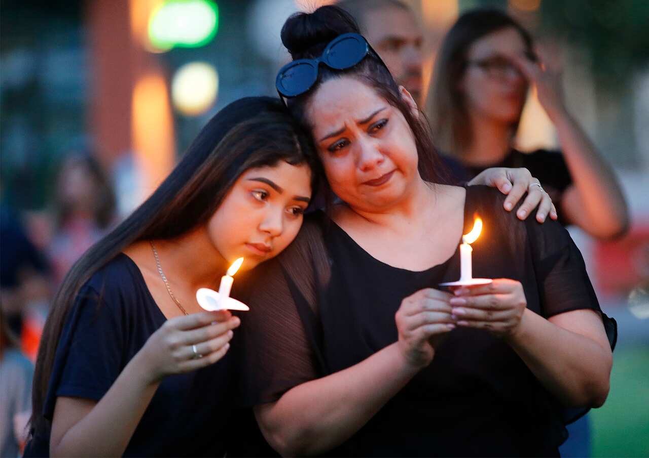 Former El Paso residents Monica Martinez (right) of McKinney and her daughter Tory, 15, during a candle light vigil.
