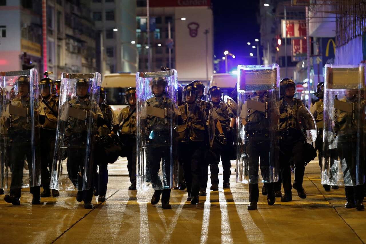 Policemen in riot gears arrive after residents and protesters gather outside a police station to demand police release a student leader.