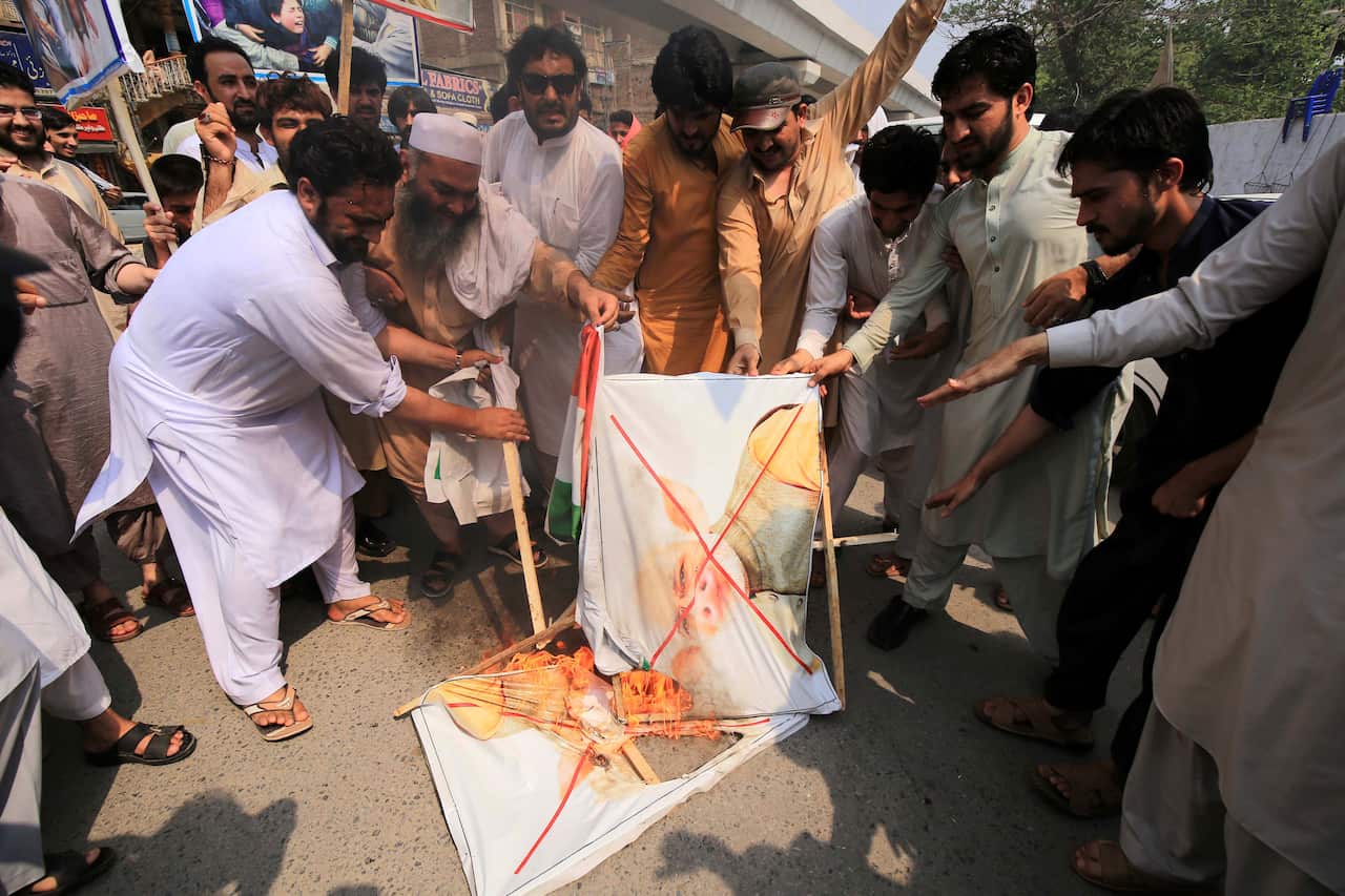Demonstrators burn a poster of the Indian PM as they protest in solidarity with the people of Kashmir.