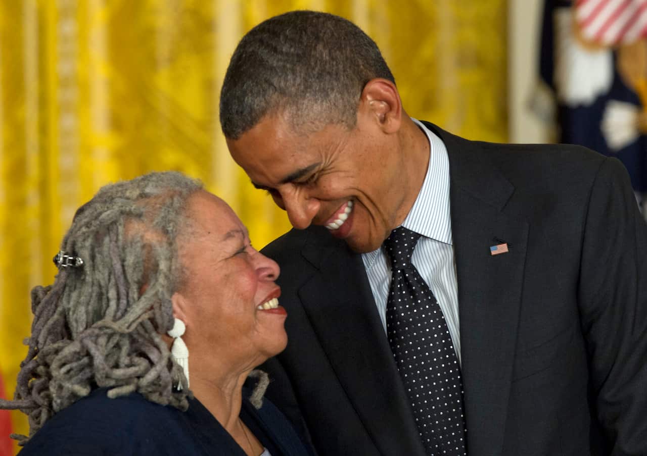 Former US President Barack Obama looks to author Toni Morrison before awarding her the Presidential Medal of Freedom in 2012. 
