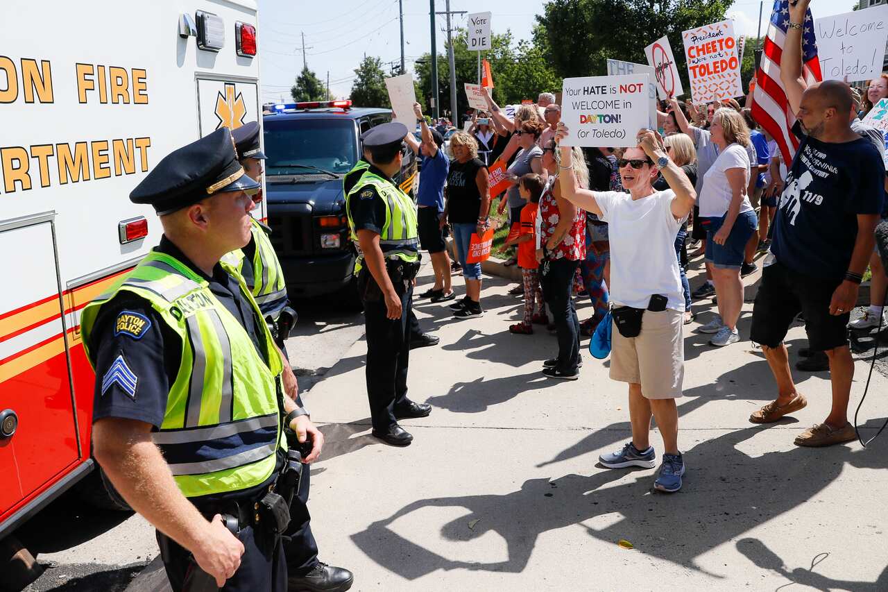 Demonstrators chant as they protest the arrival of President Donald Trump outside Miami Valley Hospital.