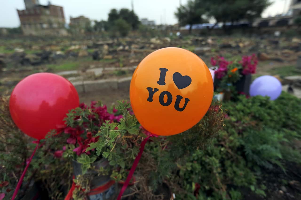 Balloons are placed on a grave at a cemetery on the first day of Eid al-Adha festival, in Sanaa, Yemen.