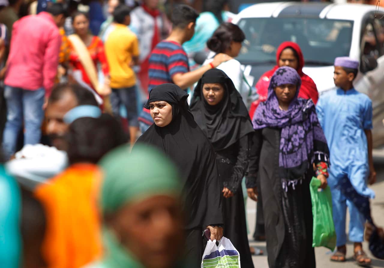 People walk through a Sunday market on the eve of Eid al Adha, In Jammu, India, Sunday, Aug.11, 2019. 