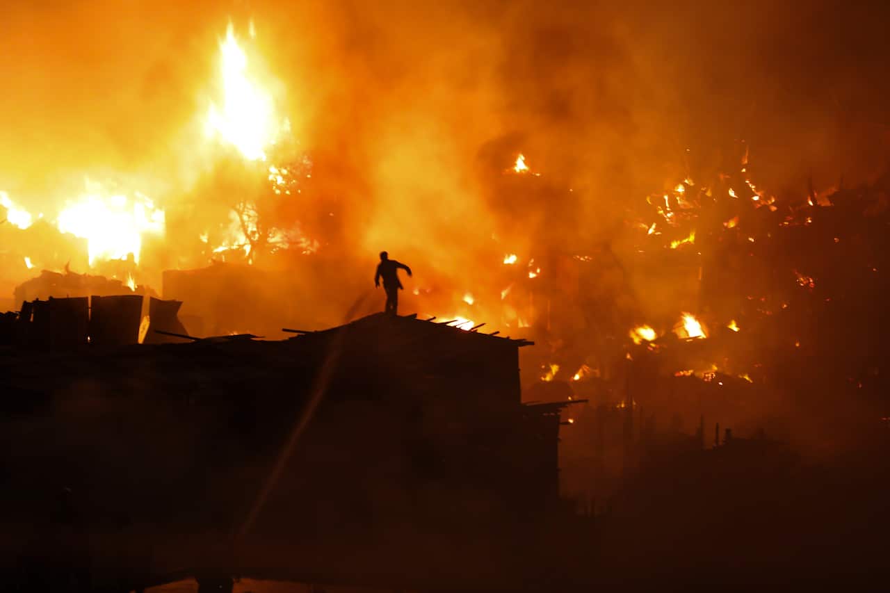 Local people help firefighters to douse a fire in a slum in Mirpur, Dhaka, Bangladesh on Friday, August 16, 2019. More than 1,000 shanties of the slum were burnt in the fire. (Photo by Salahuddin Ahmed/Sipa USA).