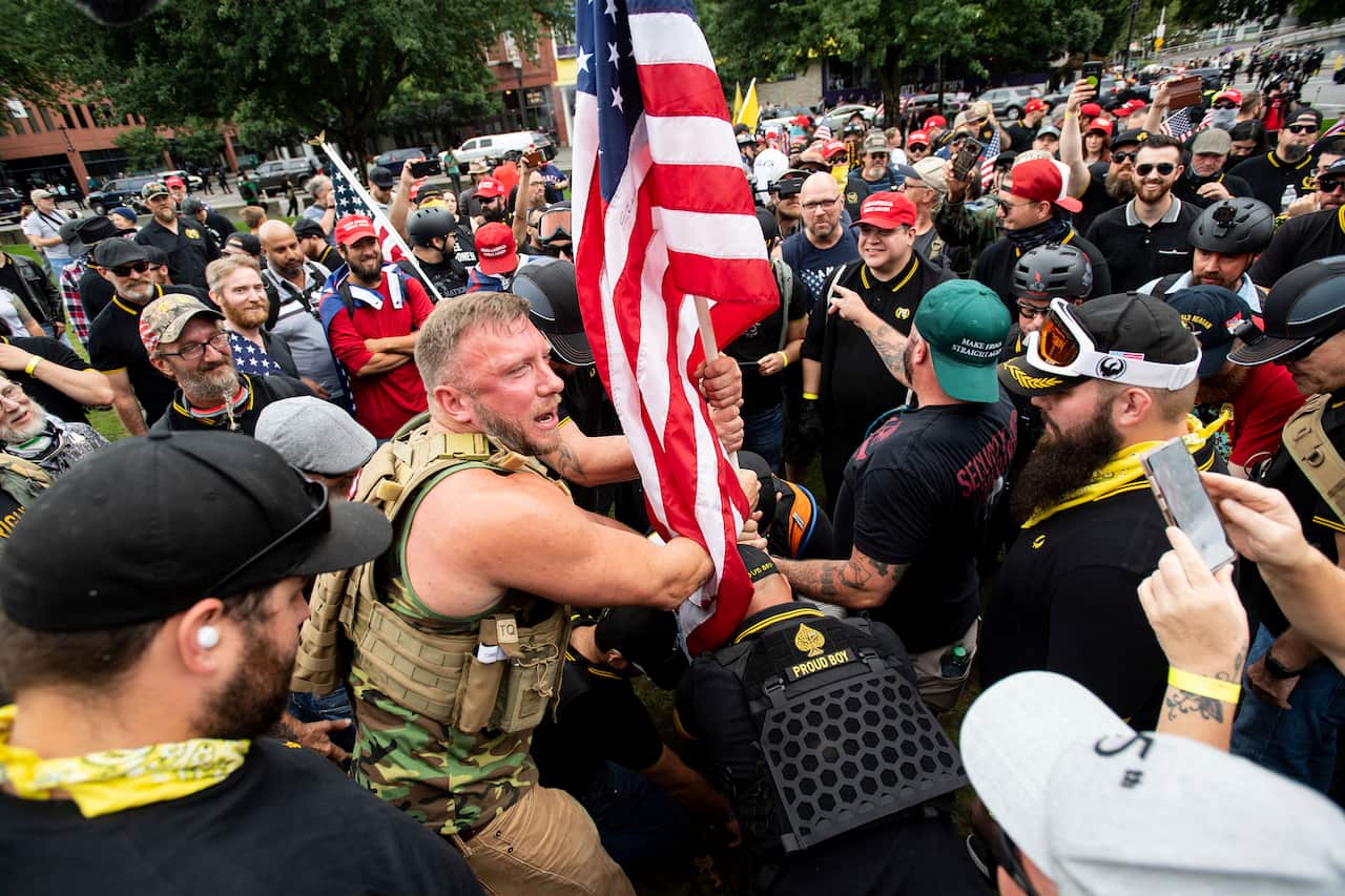 Joseph Oakman and fellow Proud Boys plant a flag in Tom McCall Waterfront Park during a rally in Portland, Oregon in 2019.