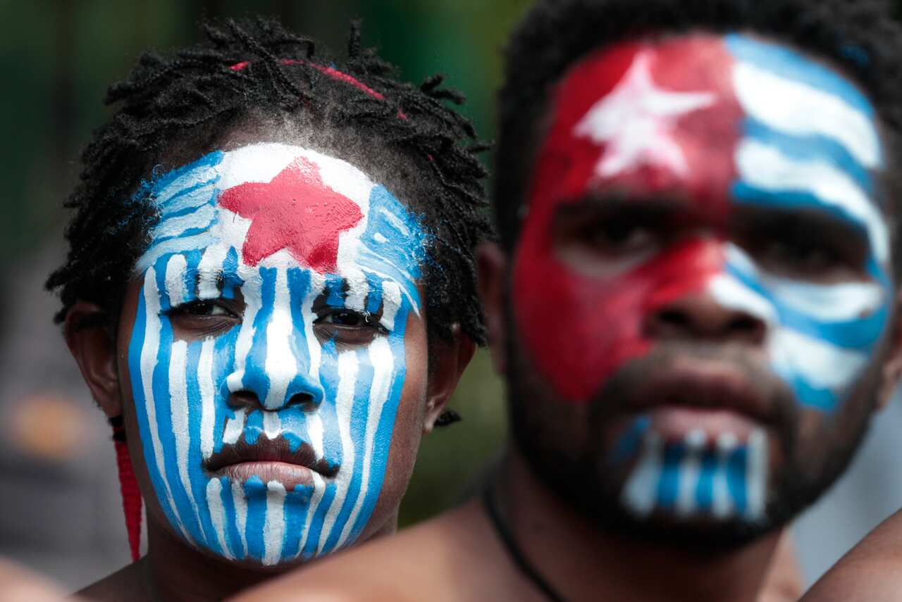 A Papuan activist with their face painted with the colors of the separatist Morning Star flag in Jakarta, Indonesia, Thursday, Aug. 22, 2019.