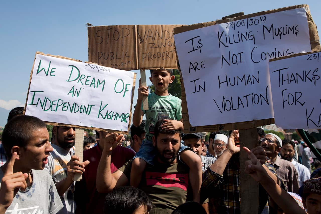 Kashmiri men hold placards and shout pro-freedom slogans during a protest after Friday prayers on the outskirts of Srinagar.