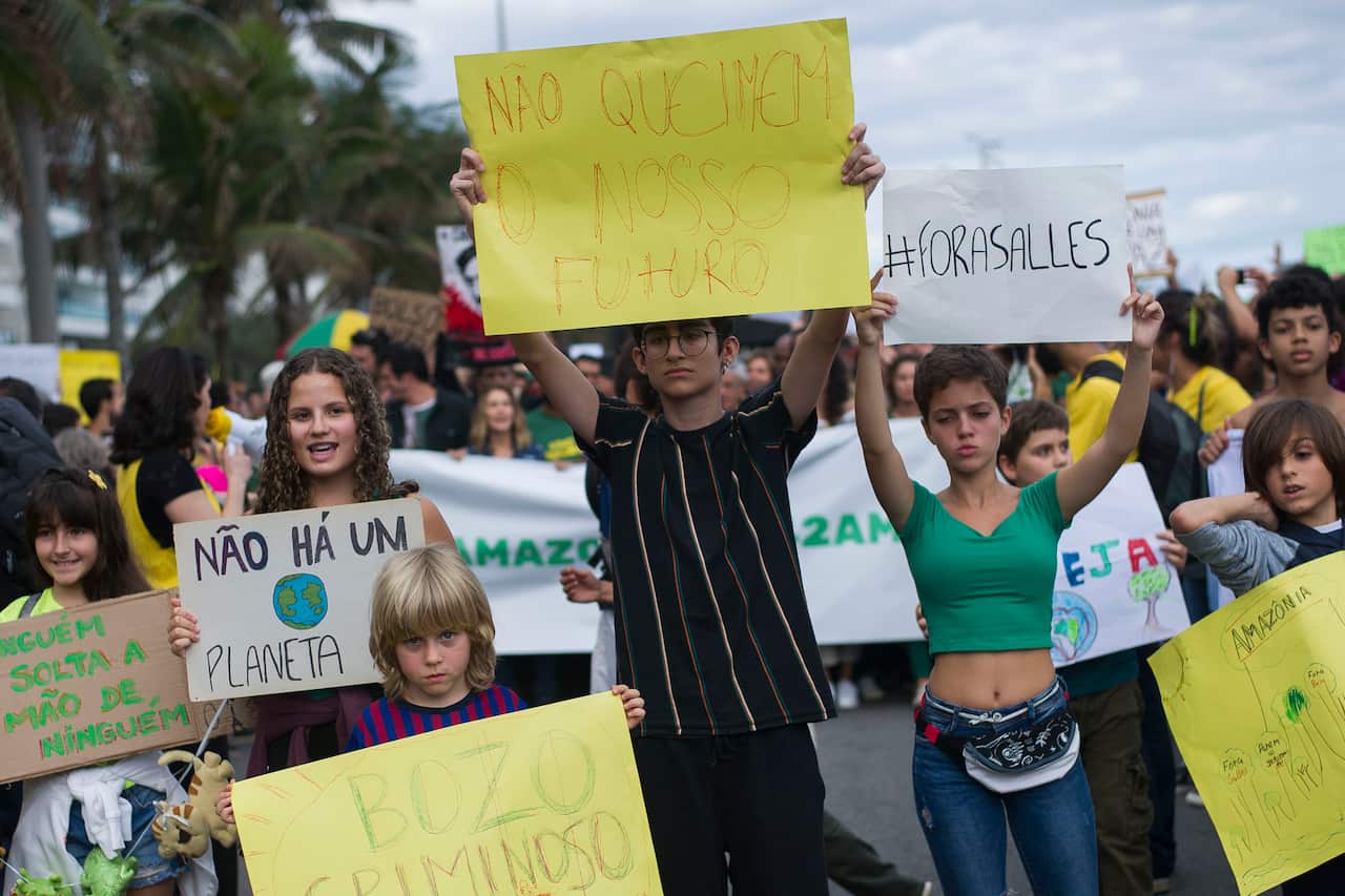 Children hold signs during a protest in defense of the Amazon while wildfires burn in that region, in Rio de Janeiro, Brazil, Sunday, Aug, 25