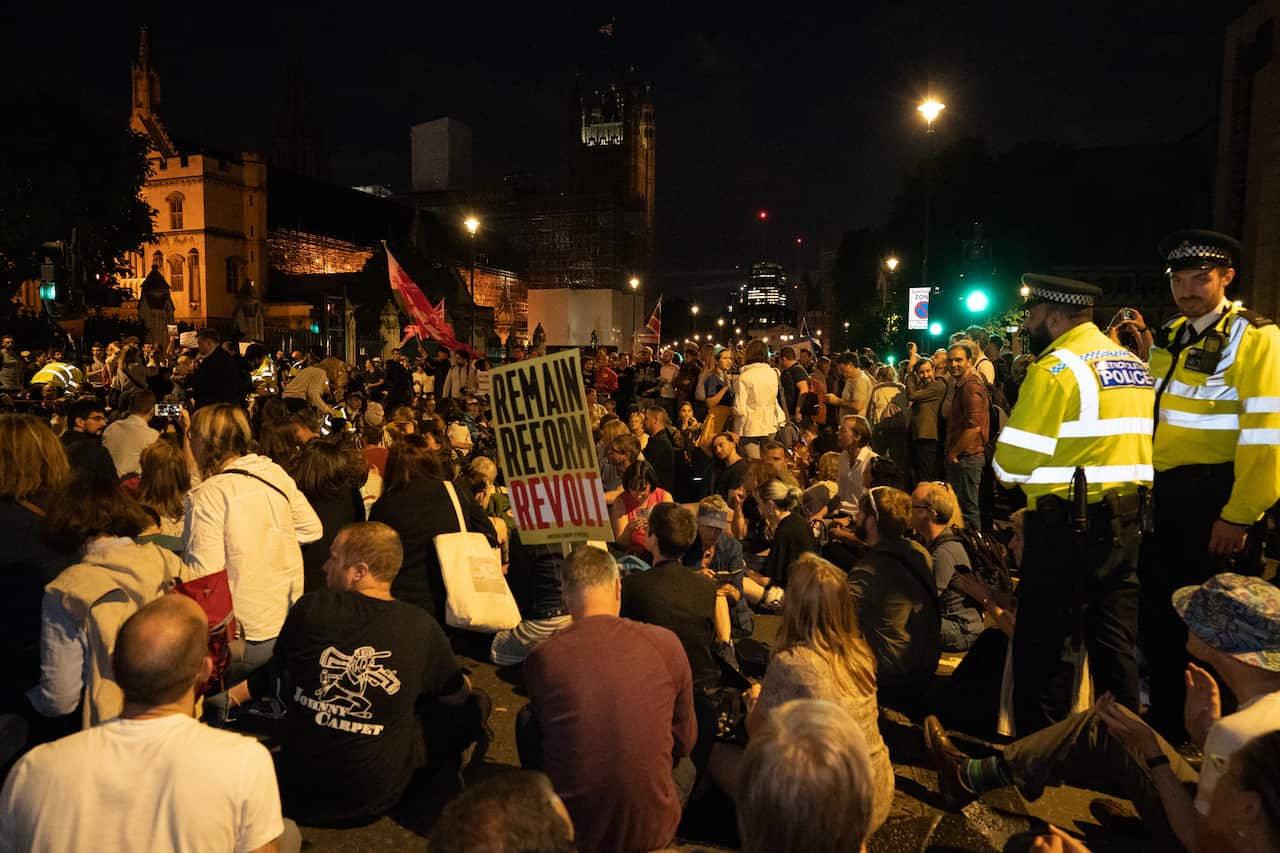 Police attempt to clear protesters outside the houses of parliament in London.