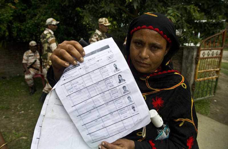 A woman displays a document that shows inclusion of her name in the final list of the National Register of Citizens (NRC) 