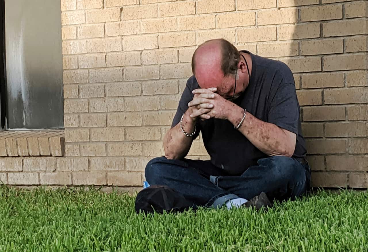 A man prays outside of the Medical Center Hospital Emergency room in Odessa.
