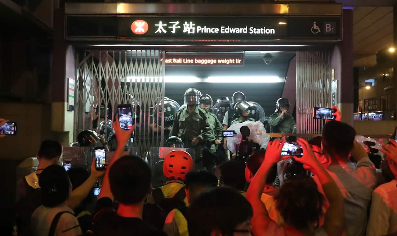 Police officers stand at the entrance to a subway station in Hong Kong.
