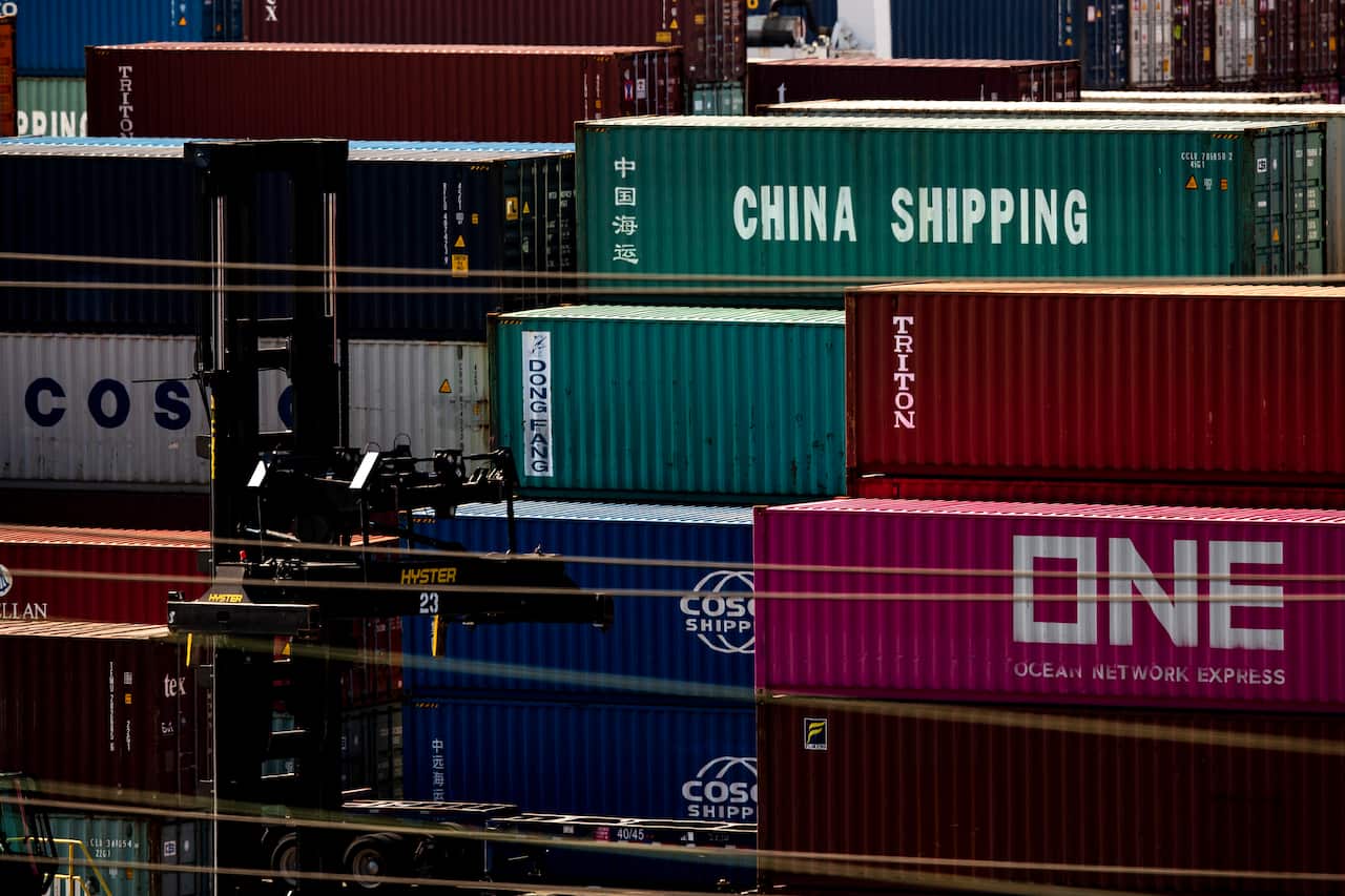 Containers reading 'China Shipping' and 'Cosco Shipping' (China Ocean Shipping Company) sit on the docks at the Los Angeles Port.