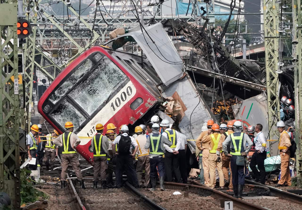 Authorities work at the scene of a train crash in Yokohama, south of Tokyo, Japan, 05 September 2019. According to media reports, more than 30 people were injured after a train hit a track at a crossing.  EPA/KIMIMASA MAYAMA