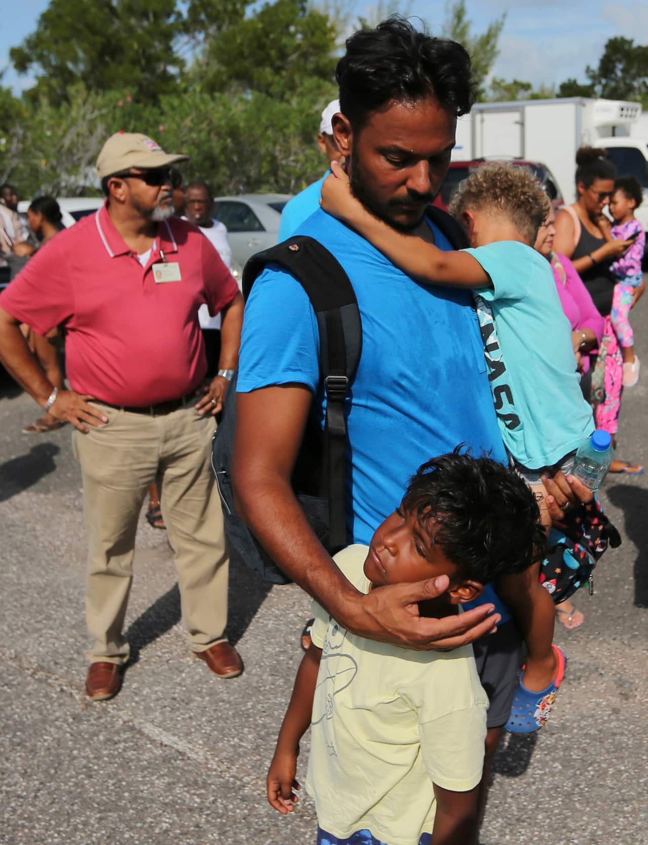Steven Turnquest comforts their sons, Leslie and Kile after their being evacuated form Abaco in Nassau, Bahamas.