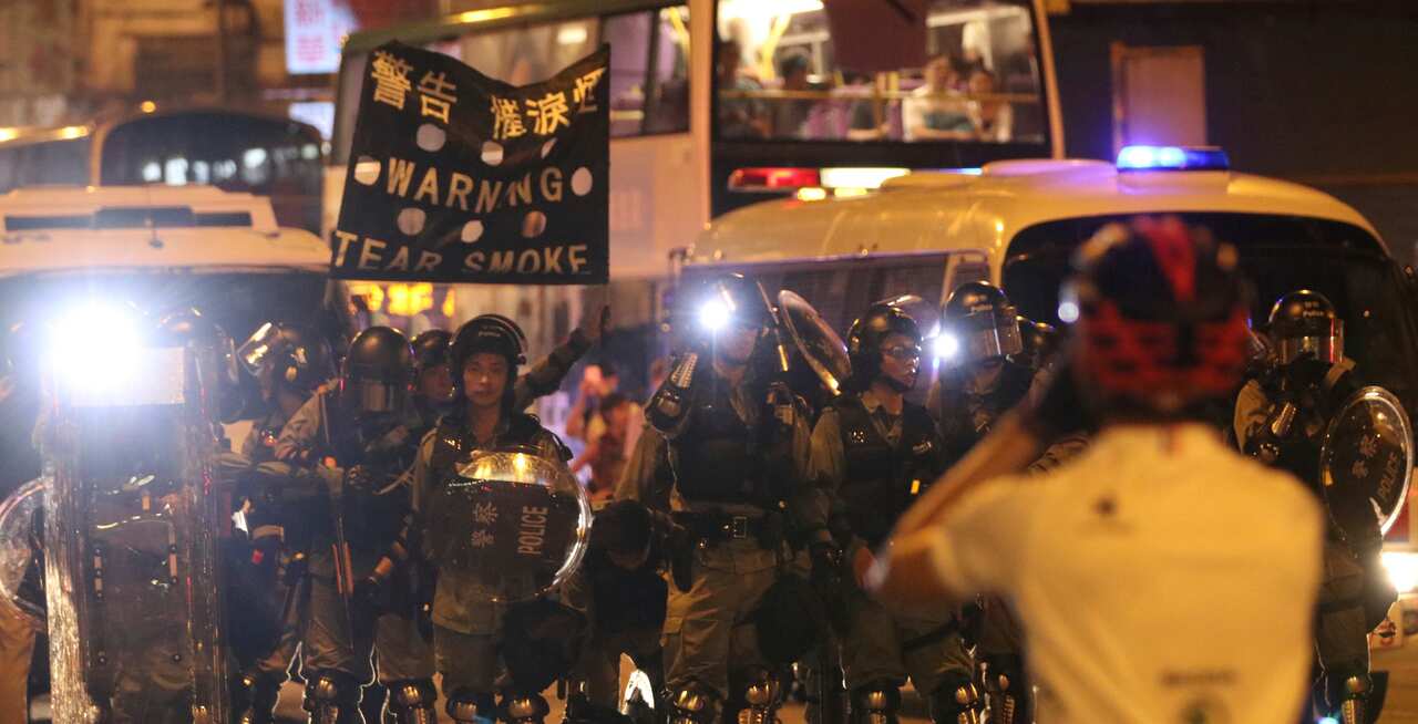 Police shows a banner to warn tear smoke during the protest rally in Hong Kong.