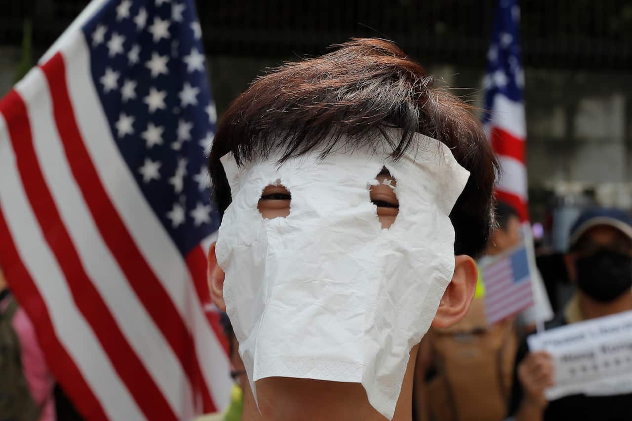 A protester covers his face as he marches to the US consulate in Hong Kong.