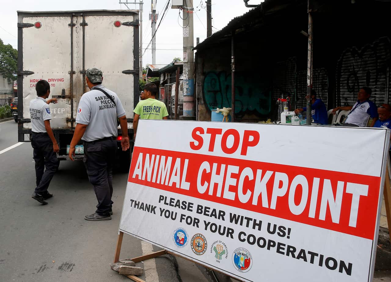 Local authorities inspect cargo vans at an animal checkpoint in Manila,Tuesday, Sept. 10, 2019