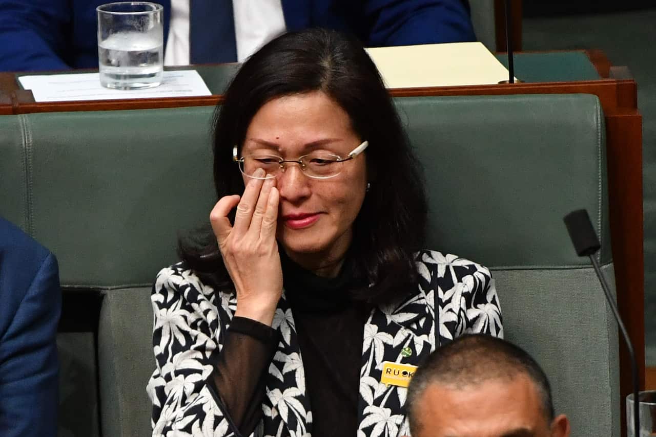 Liberal member for Chisholm Gladys Liu wipes away tears during Question Time in the House of Representatives.