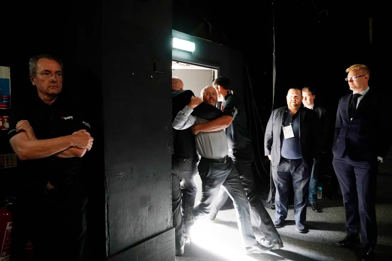 A heckler is ejected as British Prime Minister Boris Johnson delivers his speech.