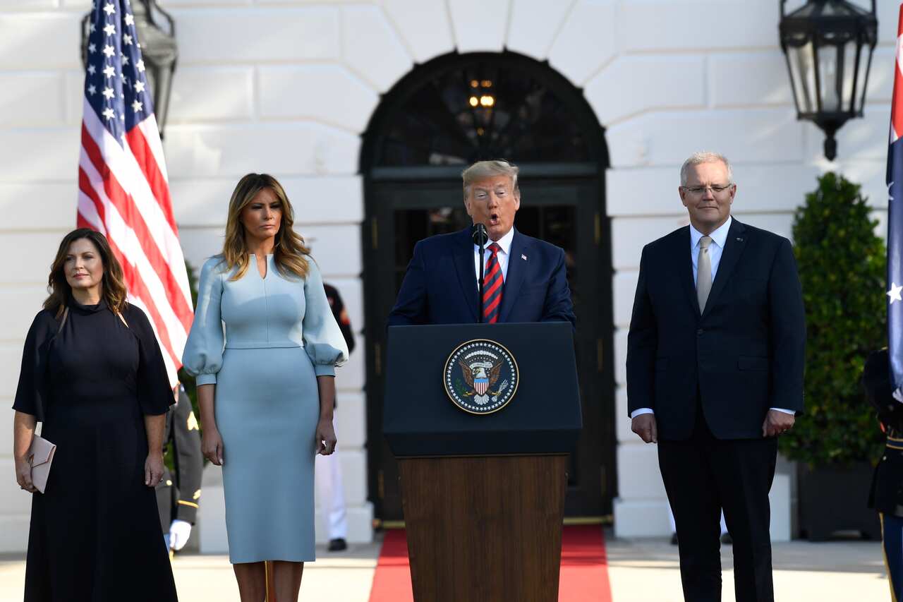 President Donald Trump speaks as Scott Morrison, Jenny Morrison (left) and Melania Trump listen. 