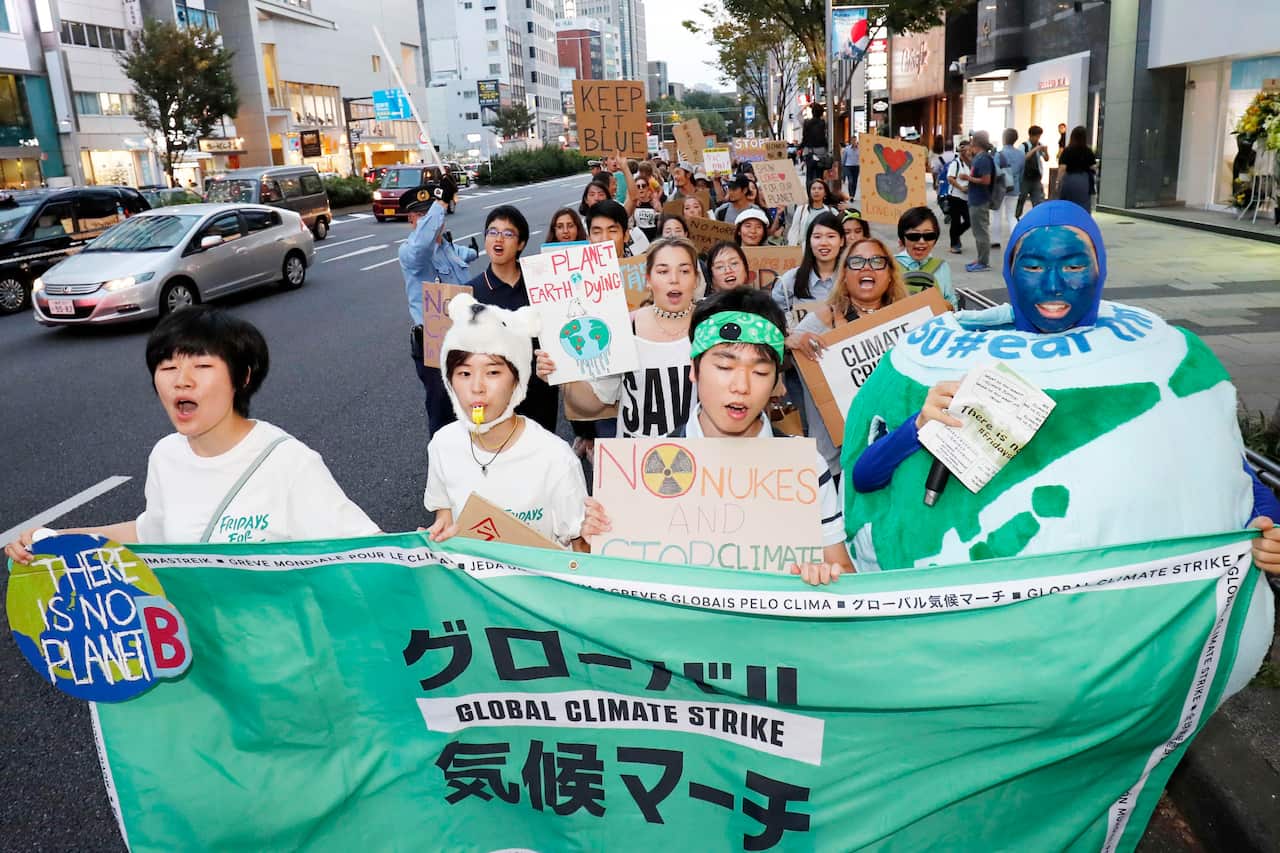 In this Friday, Sept. 20, 2019, photo, youths march on a street, calling for action to guard against climate change in Tokyo. 